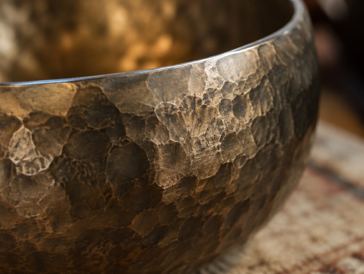 Extreme close-up of hammer marks on a bronze singing bowl